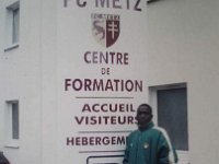 Aime Yopa-16  Photo communiquée et commentée par Aimé YOPA Avril 2011 - La sélection U15 du Cameroun en stage à Metz avant le Mondial de Montaigu 2001 - Aimé YOPA en pose devant le centre de formation du FC Metz.   Si vous avez des informations complémentaires sur cette photo, contactez nous : webmaster@efbc-cm.com